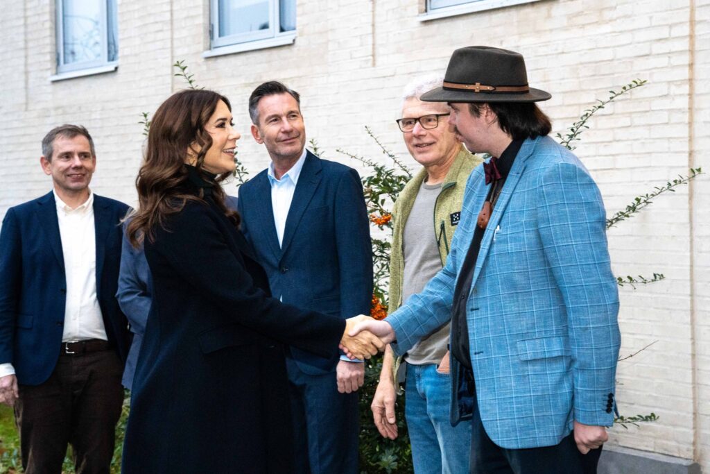 Hendes majestat Dronning Mary giver en hjemløs mand hånden.